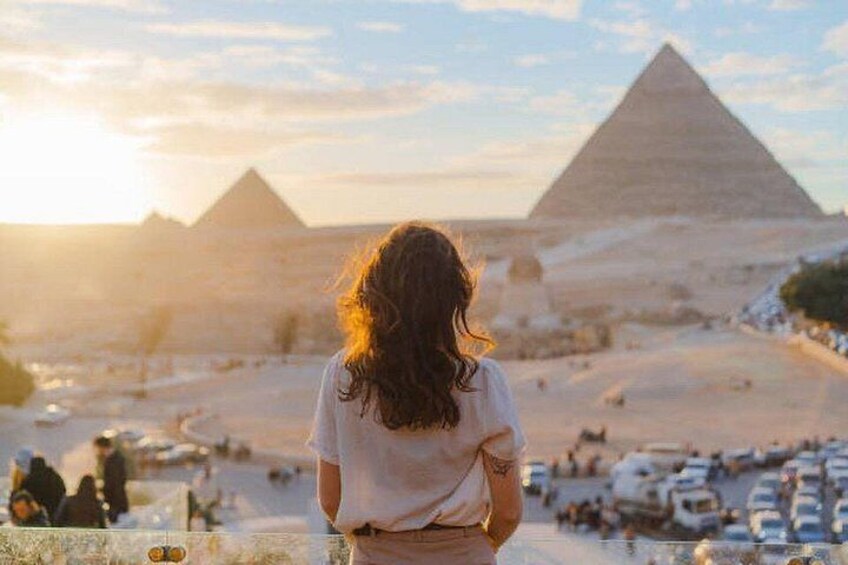 A person standing with the pyramids in the background. 1