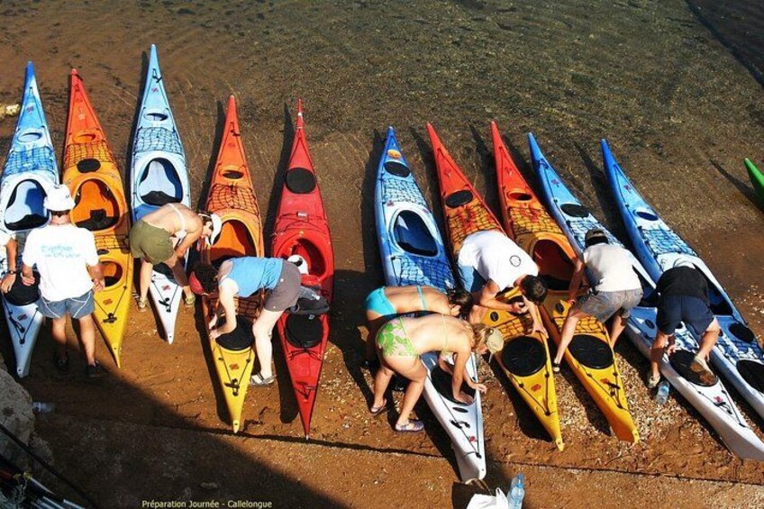 Un groupe de personnes prépare des kayaks sur une plage de sable. 5