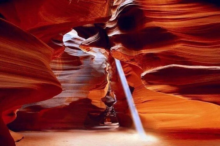 Eine schmale Schlucht mit glatten, geschwungenen Felswänden und einem schmalen Wasserlauf. 1