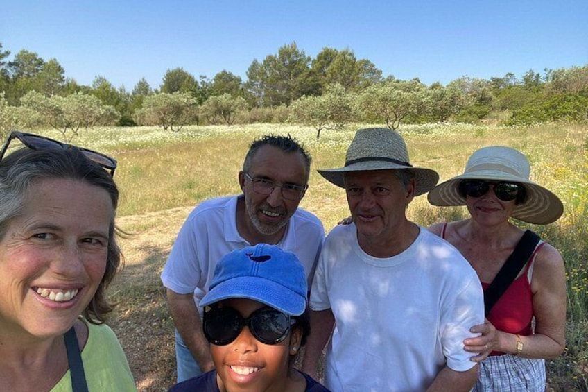 A group of people standing outdoors in a field with trees in the background. 2