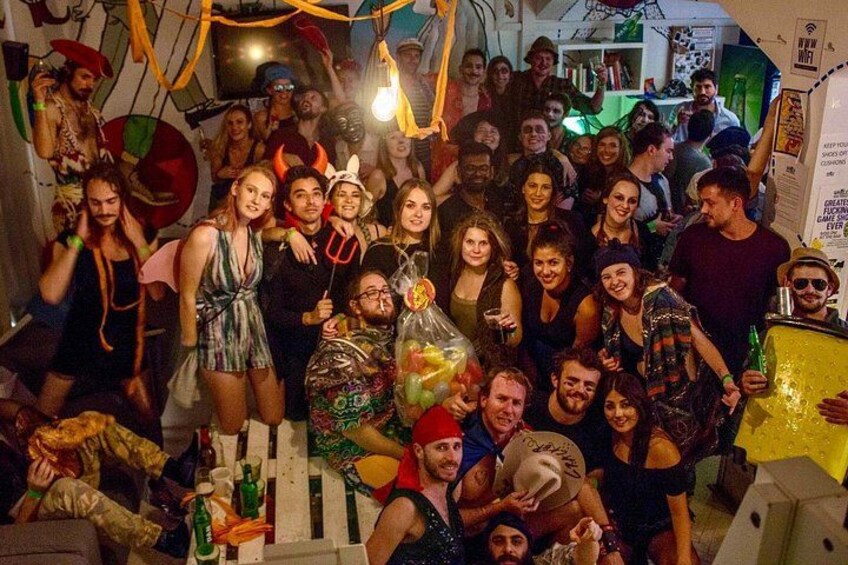 A group of people at a party with a white picket fence, balloons, and a DJ booth. 5