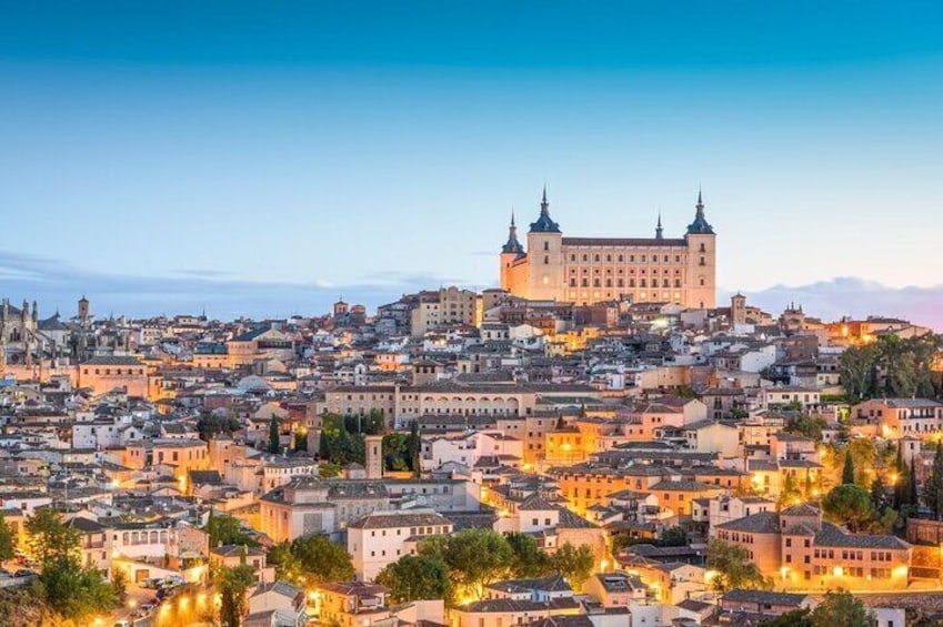 Un paisaje urbano con un edificio imponente al estilo de un castillo en el centro, rodeado de edificios muy juntos. 1