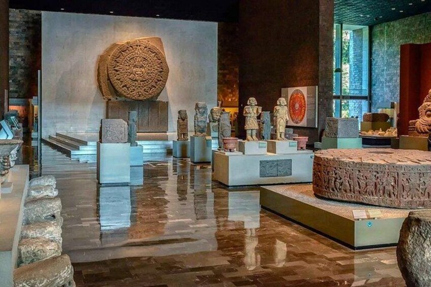 En museiinteriör med stenartefakter utställda. 3