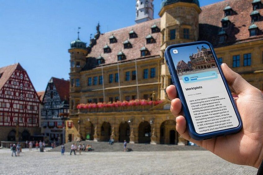 Une main tenant un smartphone affichant un guide de localisation pour la place du marché. 4