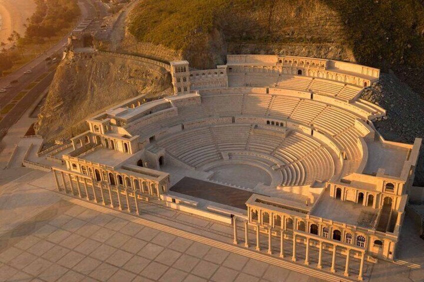 An ancient amphitheater with tiered seating and a central stage. 3