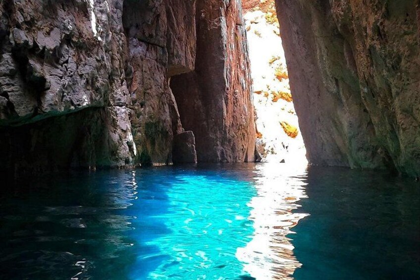 Eine natürliche Höhle mit klarem, blauem Wasser und Felswänden. 2