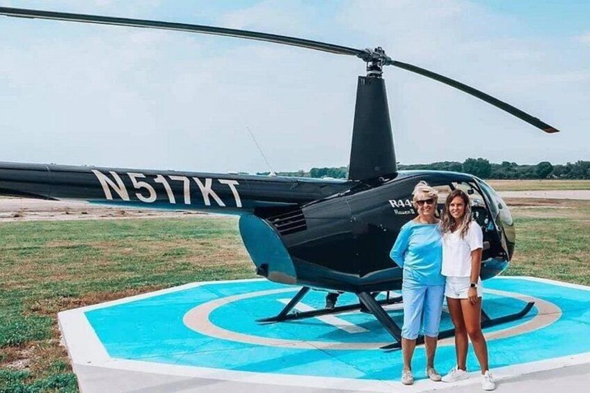 A helicopter with registration N517XT parked on a blue-painted platform. 3