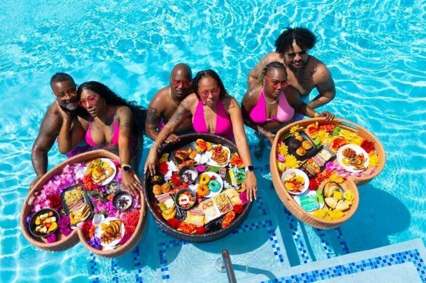 A group of people in a swimming pool with food baskets. 3