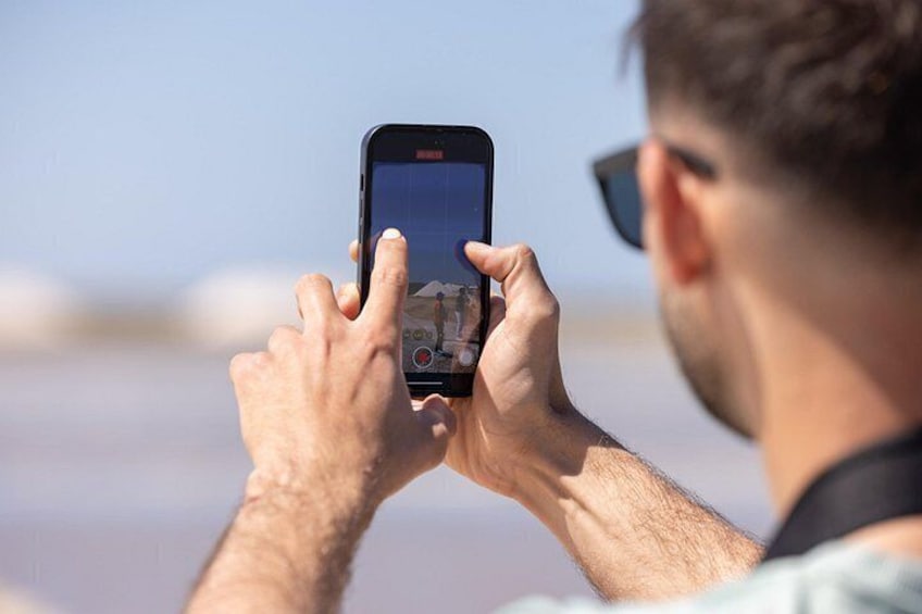 Eine Person hält ein Smartphone hoch und macht ein Foto. 3