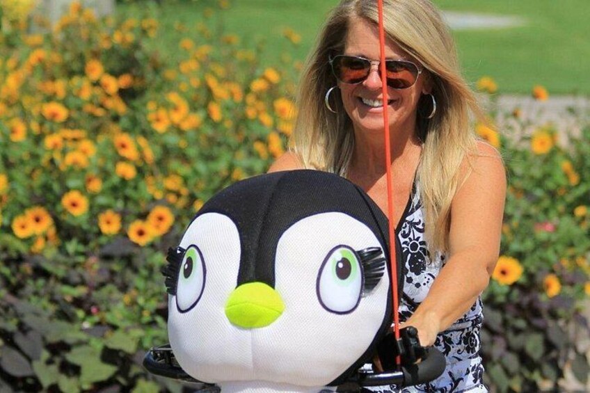 A person holding a large plush penguin toy. 1