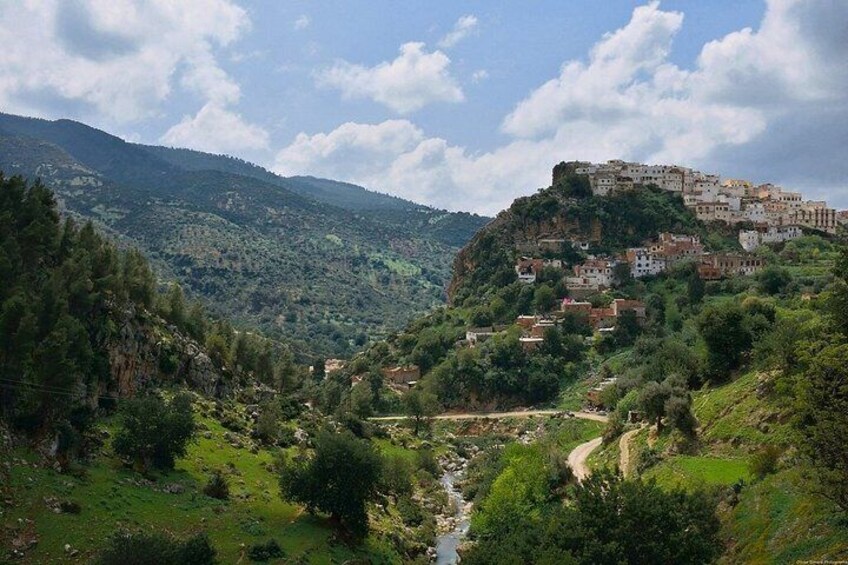 A valley with a river, a mountain, and a settlement on a hill. 4