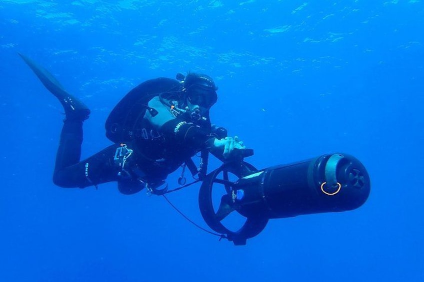 A diver with a scuba tank and equipment underwater. 5