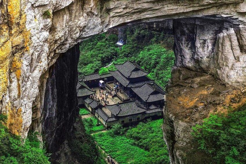 A traditional building nestled within a rock formation, surrounded by lush greenery. 2