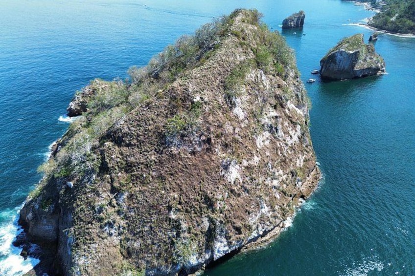 Una isla rocosa rodeada de aguas azules cristalinas. 2