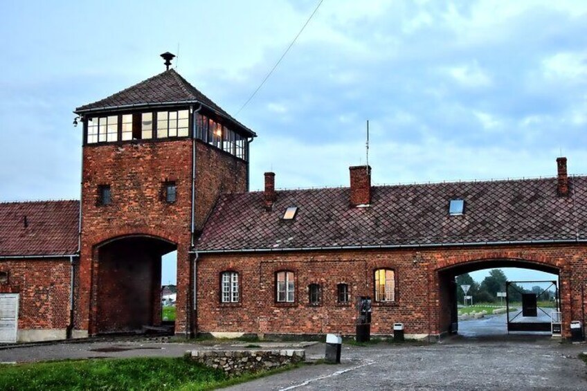Un bâtiment en briques doté d’une tour, d’une entrée en arc de cercle et d’une zone pavée devant. 5