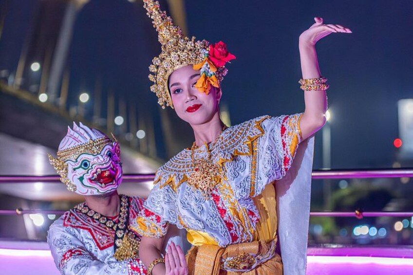 A person in traditional attire with a headdress and a mask, holding a decorative object. 2