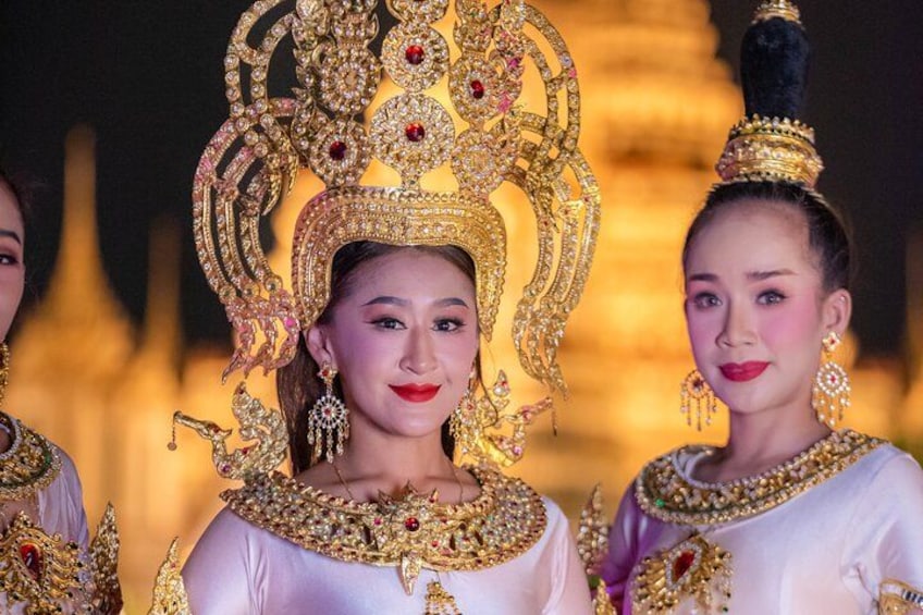 A person wearing a large, ornate headdress with intricate designs and gemstones. 5
