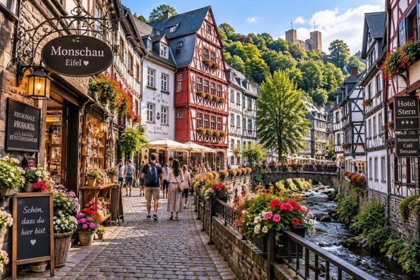 A cobblestone street lined with traditional half-timbered buildings, a river, and blooming flowers. 4