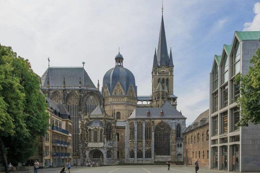 A historic cathedral with a prominent dome and spires, surrounded by modern buildings. 1
