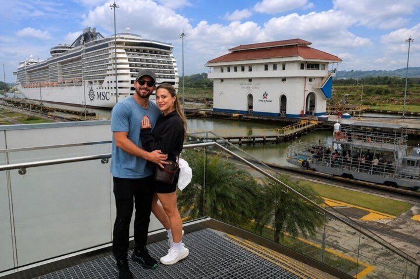 A cruise ship, a white building with a red roof, and a river. 3