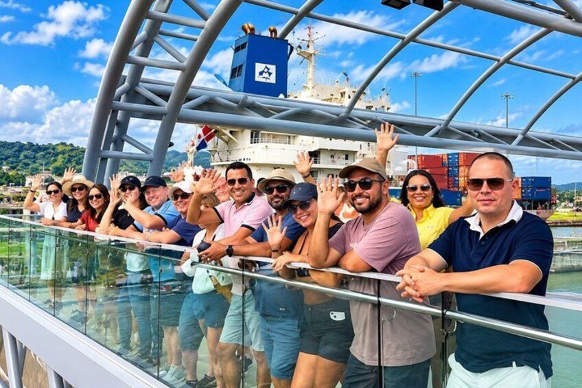 A group of people on a cruise ship deck, waving and looking out at the sea. 4