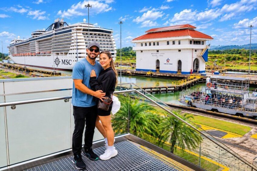 A cruise ship, a white building with a red roof, and a river. 5