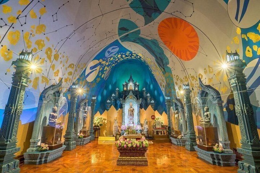 An ornate interior with a central altar, decorative columns, and a colorful ceiling. 2