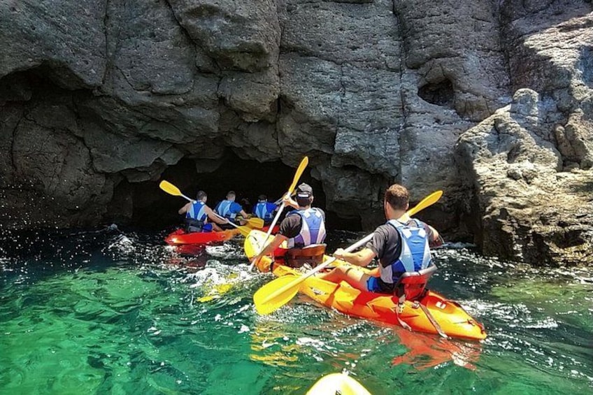 People kayaking through a rocky cave. 3