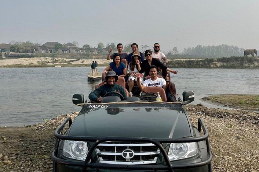 A group of people on a boat near a river with a car in the foreground. 2