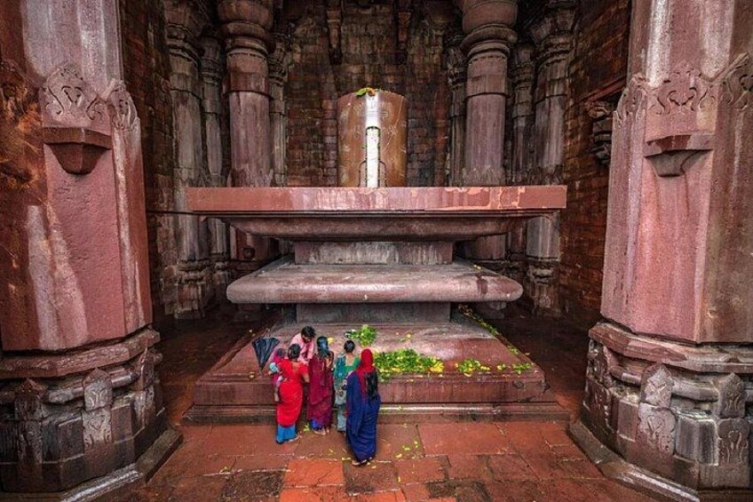 A stone structure with a central pillar, surrounded by carved stone columns. 3