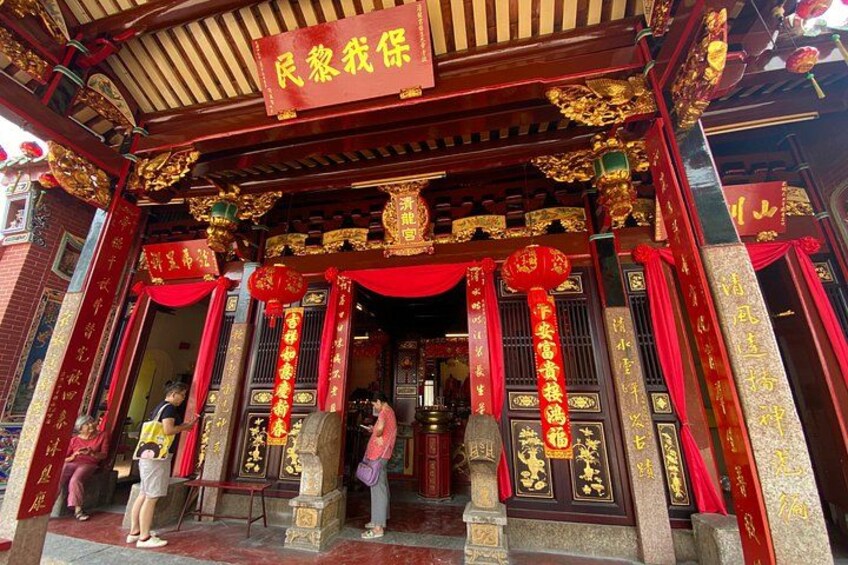A traditional Chinese temple entrance with red decorations and golden ornaments. 5