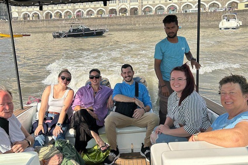 Un grupo de personas en un bote, con un río y un puente al fondo. 4