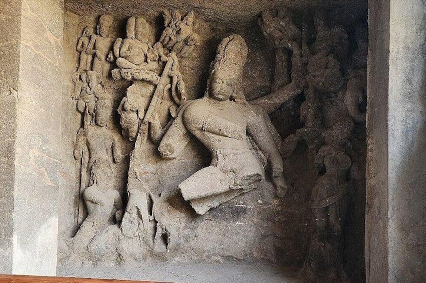Un relieve de arenisca con múltiples figuras, incluyendo una figura central sentada y figuras más pequeñas al fondo. 3