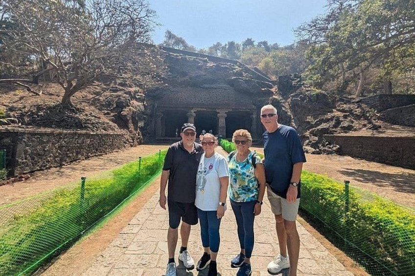 Un grupo de personas de pie sobre un camino de piedra, con un edificio histórico al fondo. 2
