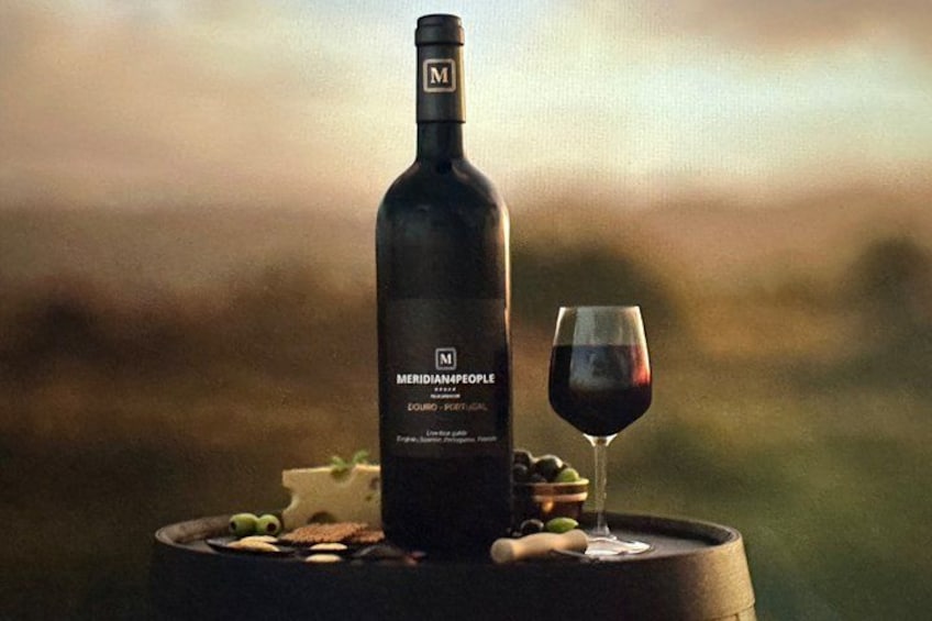 Una bottiglia di vino Meridiemapople, un bicchiere di vino rosso e un piatto con formaggio e olive su una botte. 3