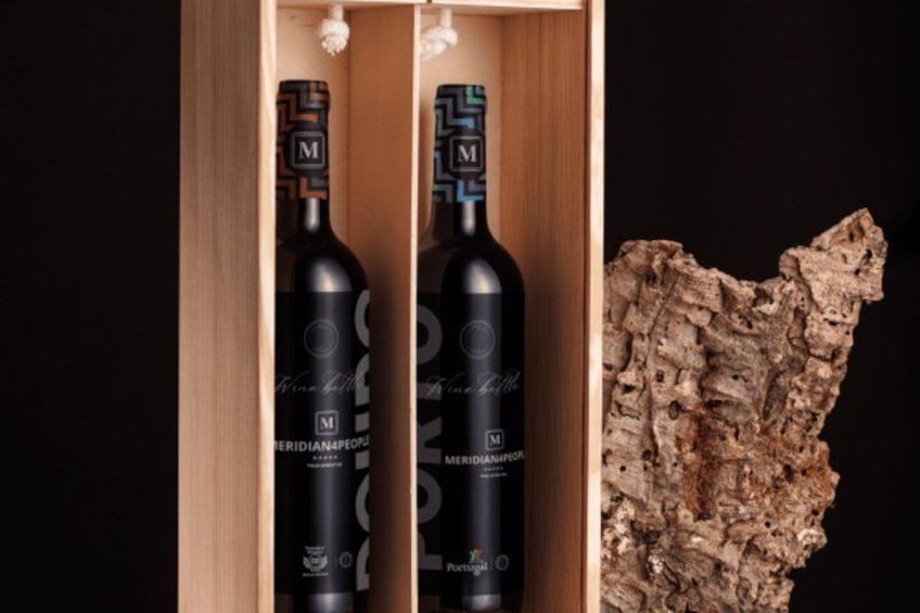 Due bottiglie di vino in una scatola di legno con una scultura di roccia dalla superficie irregolare accanto. 2