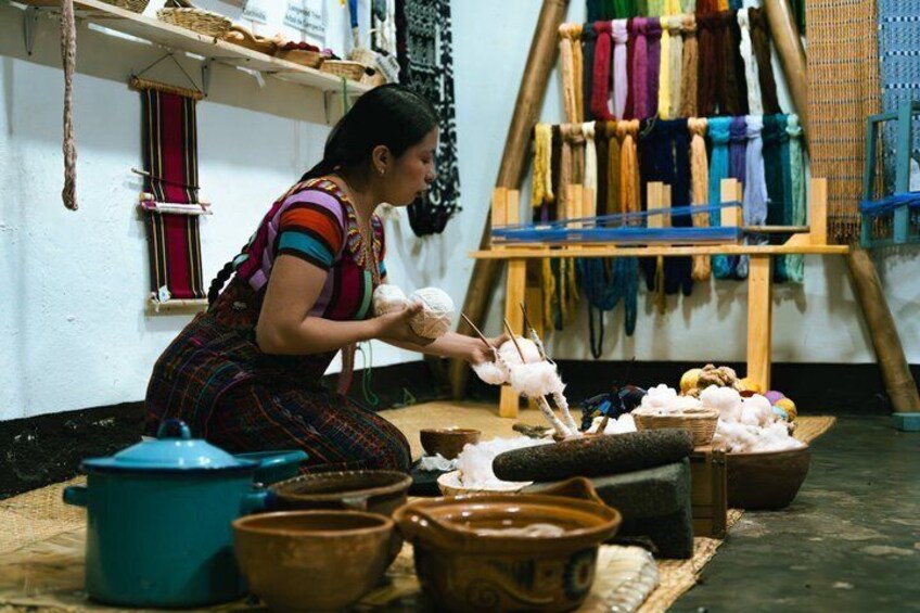 A person weaving with colorful threads on a loom. 5