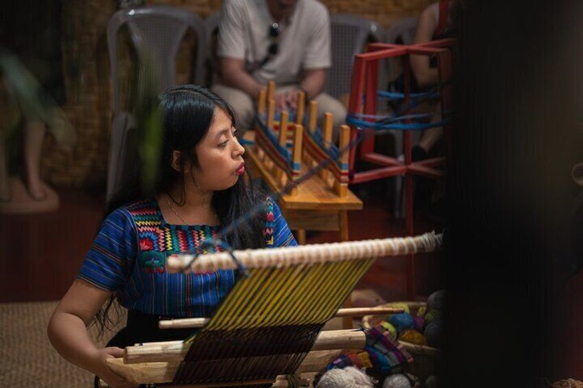 A person weaving with a loom. 5