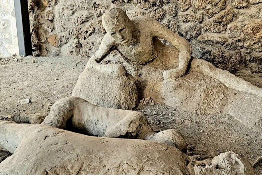Een stenen beeldhouwing van een rustend figuur in een grot. 1