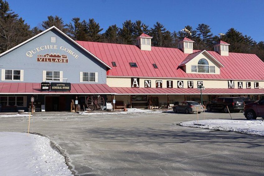 A building with a red roof and a sign that reads 'Antique Mall.' 1