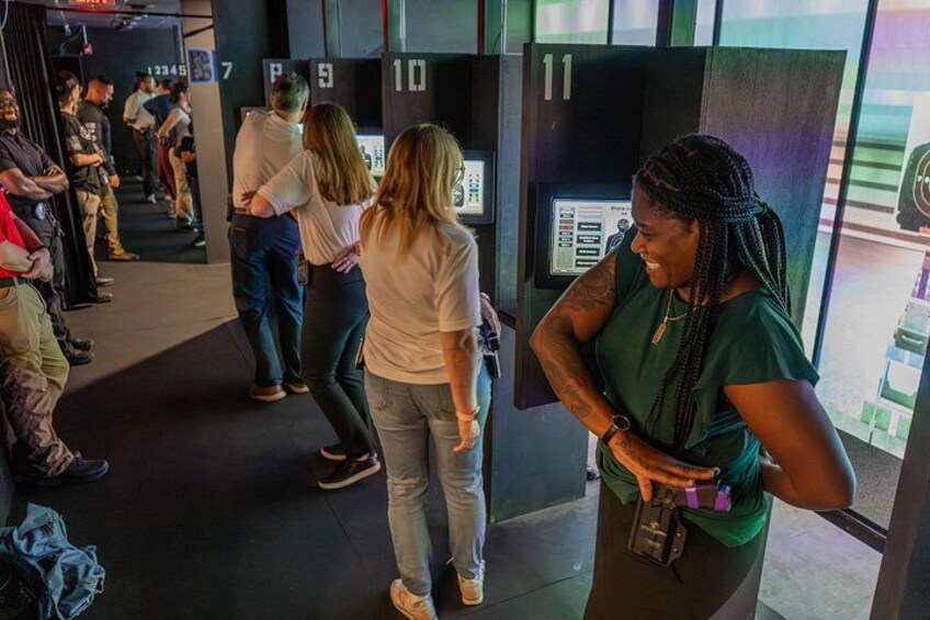 Un grupo de personas en un espacio interior moderno con taquillas numeradas, una cámara y una persona sosteniendo un teléfono. 5