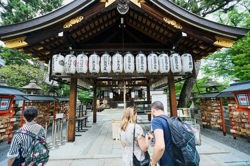 A traditional Japanese structure with a curved roof and hanging lanterns. 3