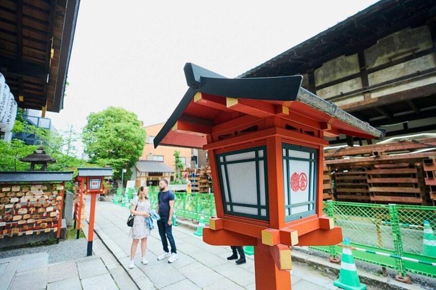 A traditional Japanese torii gate, a stone lantern, and a wooden structure with a red roof. 5