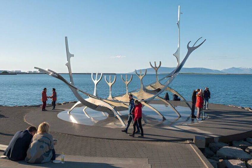 A sculpture of intertwined branches by the water. 1