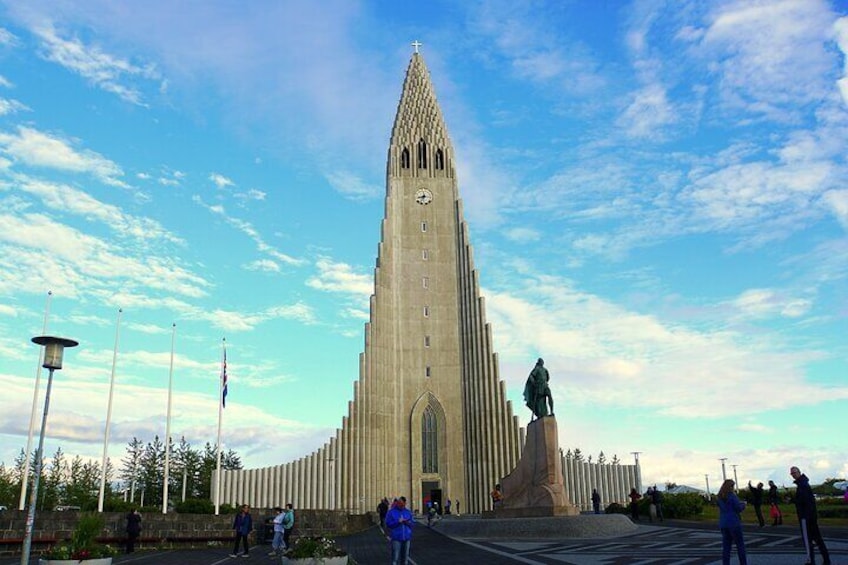 A tall, pointed church with a statue in front. 2