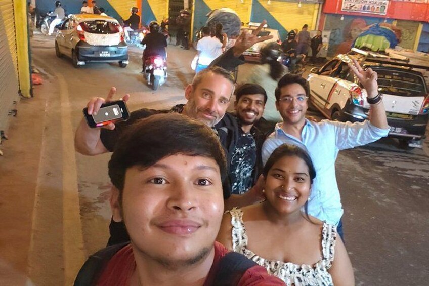 Un groupe de personnes prenant un selfie avec une scène de rue en arrière-plan. 5