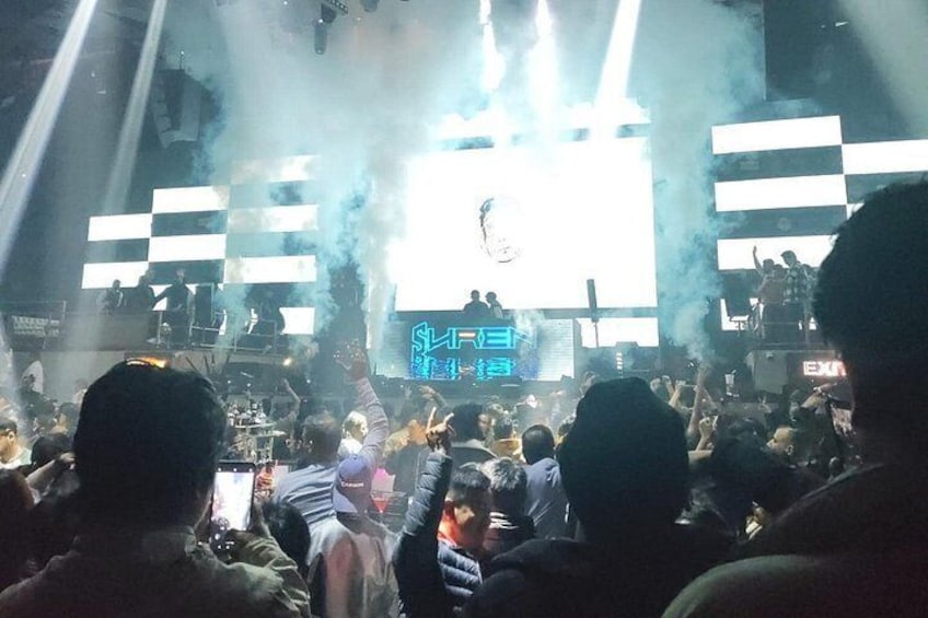 Een concert met een groot publiek, podiumverlichting en rookeffecten. 1