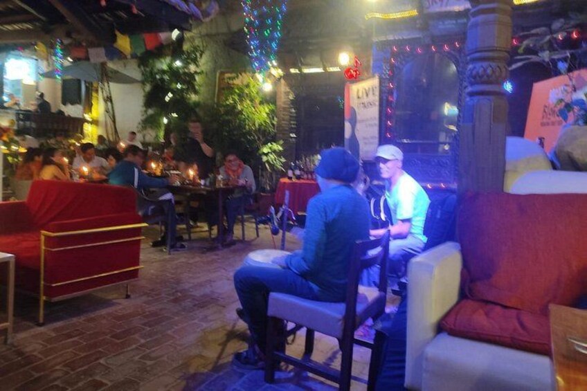 Een restaurant met rode stoelen en tafels, en een feestelijke sfeer met hangende decoraties. 2