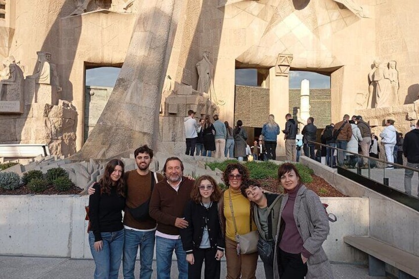 A group of people posing in front of a large, modern architectural structure with geometric shapes and sculptures. 5