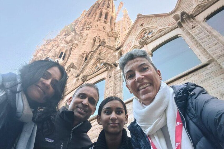 A group of people taking a selfie in front of a historic building with intricate architecture. 2